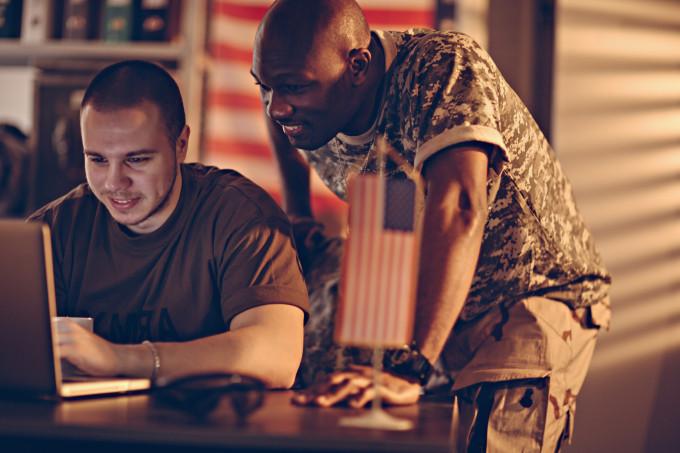 Two military men using a laptop